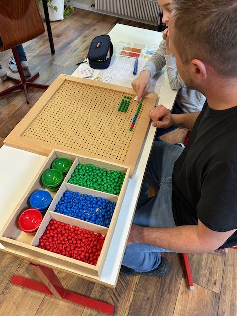 Un éducateur Montessori accompagne un enfant dans une activité